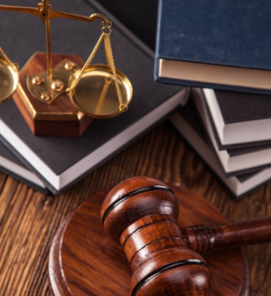 Books, gavel and lady liberty scale on a desk at US Business Attorney office.